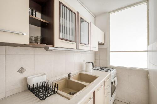 a white kitchen with a sink and a stove at Labo Apartment Niska by Old Town in Warsaw