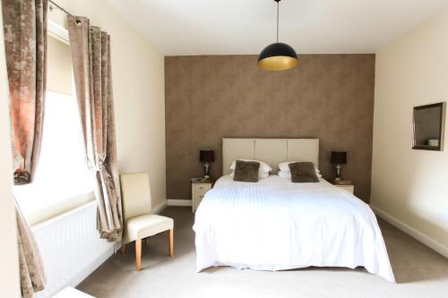 a bedroom with a white bed and a window at The Kings Head in Louth