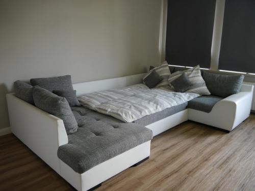 Cette chambre comprend un lit, un canapé et une chaise. dans l'établissement Ferienwohnung Zwischen Marsch u. Geest, à Eddelak