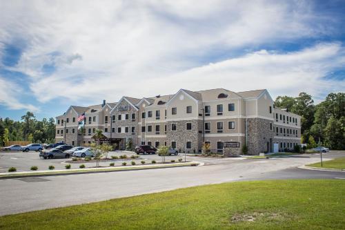 a large building with cars parked in a parking lot at Staybridge Suites North Jacksonville by IHG in Jacksonville