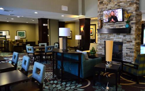a hotel lobby with a fireplace and blue chairs at Staybridge Suites North Jacksonville by IHG in Jacksonville