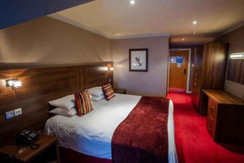 ゲーツヘッドにあるThe Gibside Hotelのベッドとテレビがあるホテルの部屋