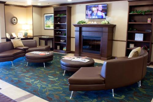 a waiting room with couches and a fireplace at Candlewood Suites Youngstown W - I-80 Niles Area by IHG in Austintown