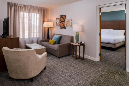 a hotel room with a bed and a couch and a chair at Staybridge Suites Indianapolis Downtown-Convention Center by IHG in Indianapolis