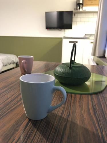 una taza de café y un tazón en una mesa en PAPILLONS De Nuit Champagne Troyes, en Troyes