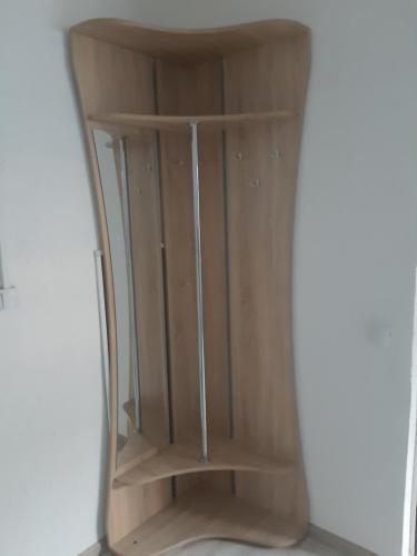 a wooden book shelf in a corner of a room at Жилье отдельное in Odesa