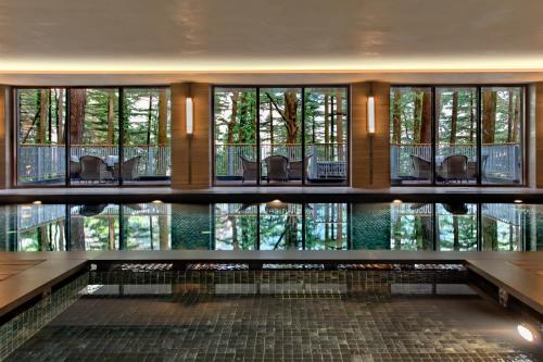 um quarto com uma piscina com cadeiras e janelas em Hyatt Regency Dharamshala Resort em Dharamshala