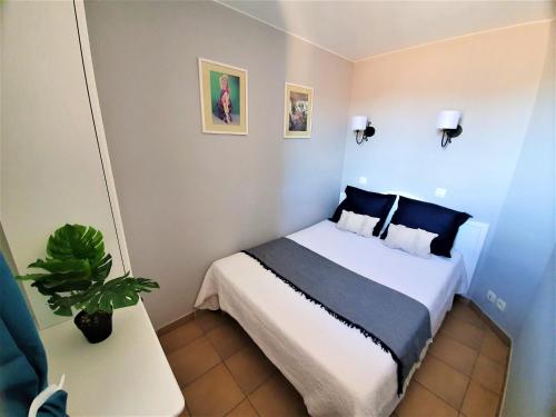 a small bedroom with a bed and a potted plant at Appartement Prestige résidence Pierre & Vacances Golfe de Saint Tropez in Grimaud