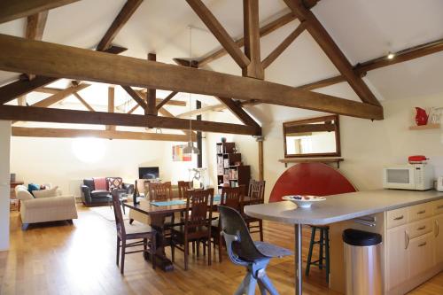 a kitchen and living room with wooden beams at Glanhenwye Courtyard Cottages in Glasbury