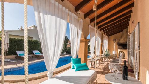 eine Terrasse mit Stühlen und einem Pool in der Unterkunft Villa Son Serra, Pool and Chill Out close to the beach in Son Serra de Marina