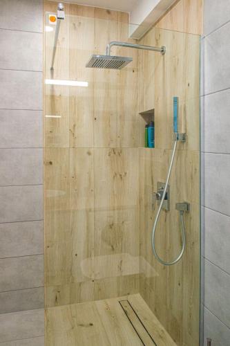 a shower with a glass door in a bathroom at Apartament Zatoka in Puck