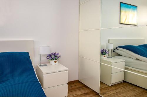a bedroom with a large mirror next to a bed at Apartament Zatoka in Puck