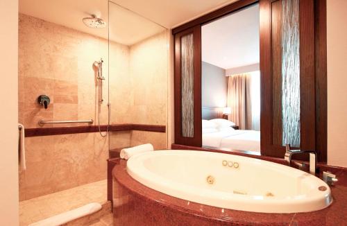 ein Bad mit einer Badewanne und ein Schlafzimmer in der Unterkunft Hyatt Regency Villahermosa in Villahermosa