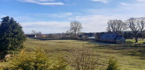 a field with a barn in the middle of it at Kiltearn Guest House in Evanton