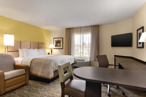 a hotel room with a bed and a table and chairs at Candlewood Suites Vestal - Binghamton by IHG in Vestal