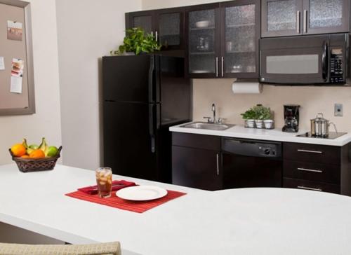a kitchen with black cabinets and a black refrigerator at Candlewood Suites Vestal - Binghamton by IHG in Vestal