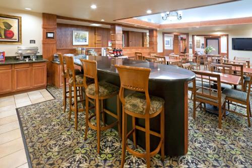 a large kitchen with a bar with wooden chairs at Staybridge Suites Lubbock-University Area, an IHG Hotel in Lubbock