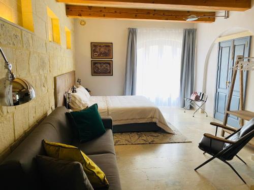 a living room with a couch and a bed at Lulu Boutique Hotel in Żebbuġ