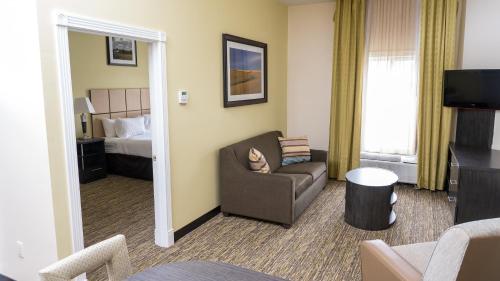 a hotel room with a couch and a bed at Candlewood Suites Saint Joseph - Benton Harbor by IHG in Stevensville
