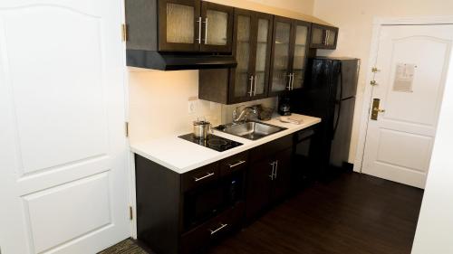 a kitchen with a sink and a black refrigerator at Candlewood Suites Saint Joseph - Benton Harbor by IHG in Stevensville