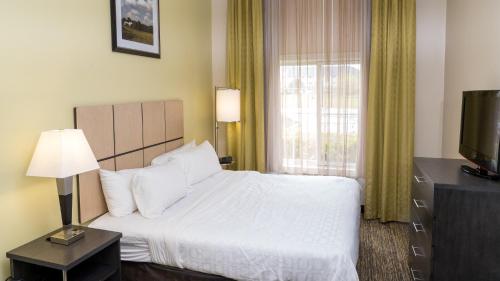 a hotel room with a bed and a window at Candlewood Suites Saint Joseph - Benton Harbor by IHG in Stevensville