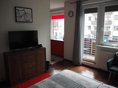 um quarto com uma televisão numa cómoda e uma janela em Szybowników 2 em Pila