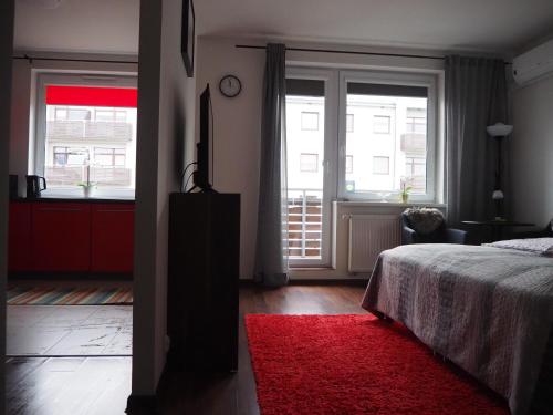 sypialnia z łóżkiem i czerwonym dywanem w obiekcie Szybowników 2 w mieście Piła