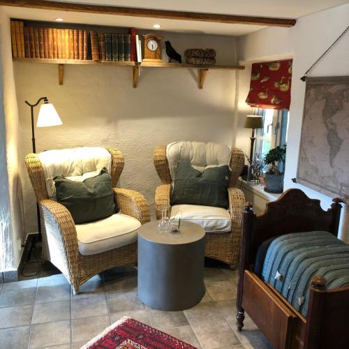 a living room with two chairs and a table at Glimminge Bed & Breakfast in Simrishamn