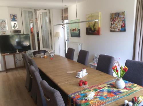 a dining room with a wooden table and chairs at Cozy Bed and Breakfast in Elst
