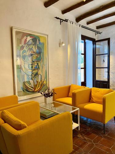 a living room with yellow couches and a painting at El Molino Estepona in Estepona