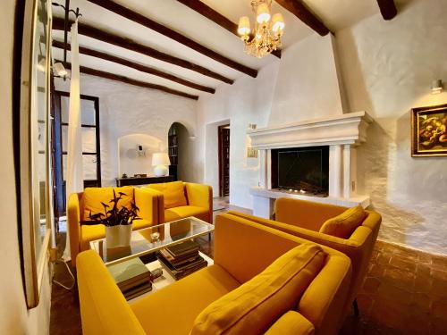 a living room with yellow couches and a fireplace at El Molino Estepona in Estepona