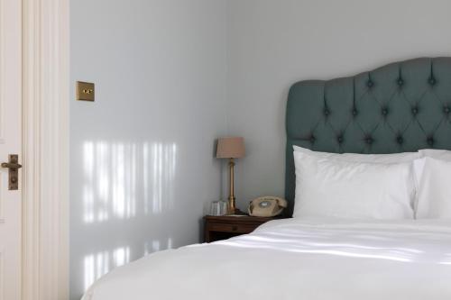 a bedroom with a bed with a green headboard and a clock at Vazisubani Estate in Vazisubani