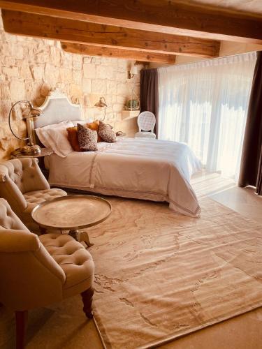 a man sitting on a bed in a bedroom at Lulu Boutique Hotel in Żebbuġ