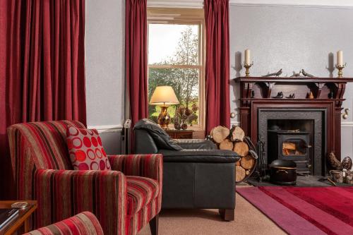 a living room with a chair and a fireplace at Kiltearn Guest House in Evanton