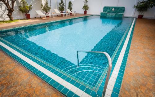 a swimming pool with a stair in the middle at Le Charme Vientiane Hotel in Vientiane