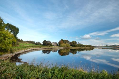 ein Fluss mit seinem Reflex im Wasser in der Unterkunft Kiltearn Guest House in Evanton