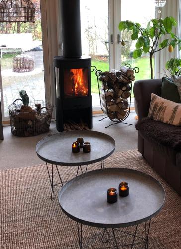 a living room with two tables and a fireplace at Glimminge Bed & Breakfast in Simrishamn