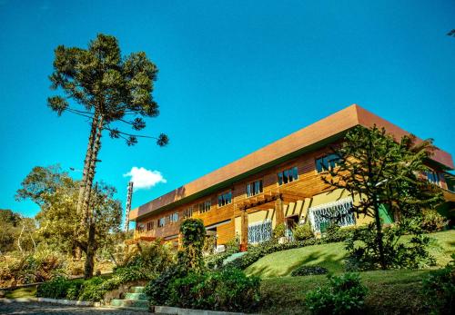 a building with a tree in front of it at Pousada São Chico Eco Village in São Francisco de Paula