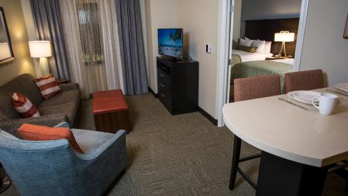 a hotel room with a bed and a living room at Staybridge Suites Lexington by IHG in Lexington