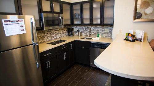 a kitchen with black cabinets and a stainless steel refrigerator at Staybridge Suites Lexington by IHG in Lexington