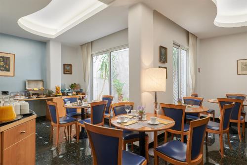 a dining room filled with tables and chairs at Athos Hotel in Athens