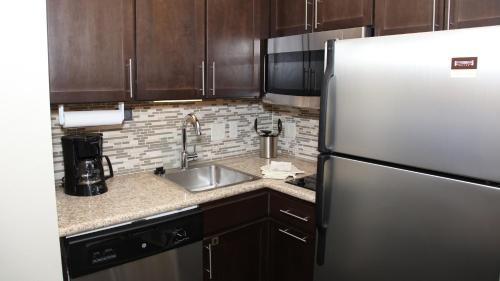a kitchen with a refrigerator and a sink at Staybridge Suites Lincoln North East by IHG in Lincoln