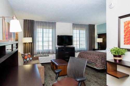 a hotel room with a bed and a living room at Staybridge Suites Lincoln North East by IHG in Lincoln