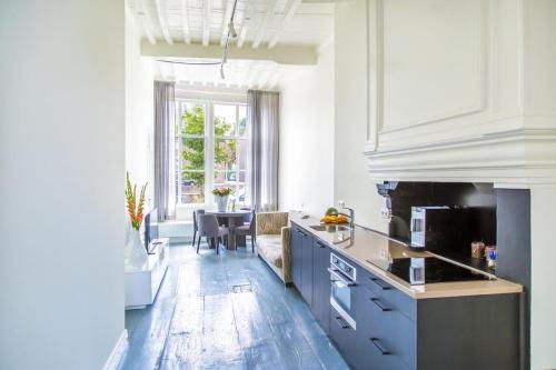 a kitchen with blue cabinets and a table in it at Appartement Middelburg4you in Middelburg