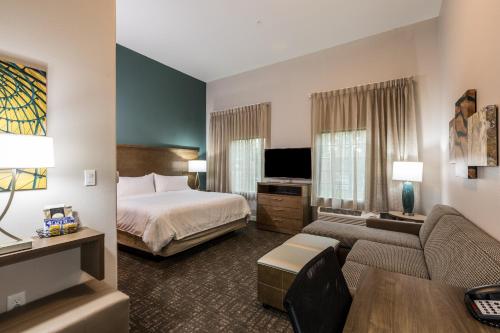 a hotel room with a bed and a couch at Staybridge Suites - Lake Jackson by IHG in Lake Jackson
