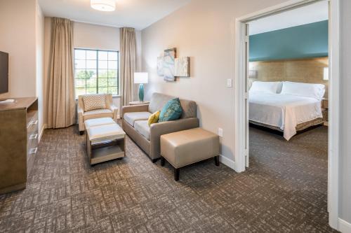 a hotel room with a bed and a couch at Staybridge Suites - Lake Jackson by IHG in Lake Jackson