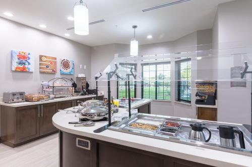 a large kitchen with a counter with a sink at Staybridge Suites - Lake Jackson by IHG in Lake Jackson