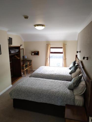 1 dormitorio con 2 camas y ventana en Tigh Fitz Bed & Breakfast en Inis Mor