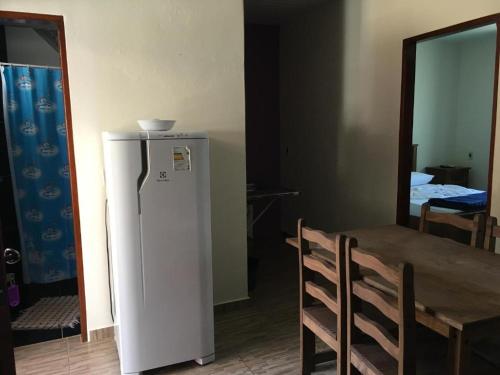 um frigorífico num quarto com uma mesa e uma sala de jantar em Flat da Pousada Avalon (Bolinha) em Alto Paraíso de Goiás