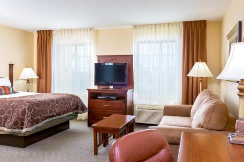 a hotel room with a bed and a tv at Staybridge Suites McAllen by IHG in McAllen
